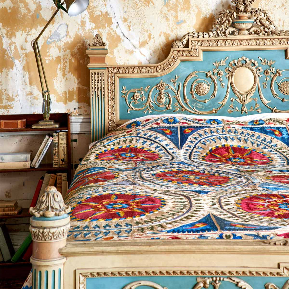 In use view of Mekhann's multicoloured medallion throw, showing the medallion throw covering an entire bed spread.