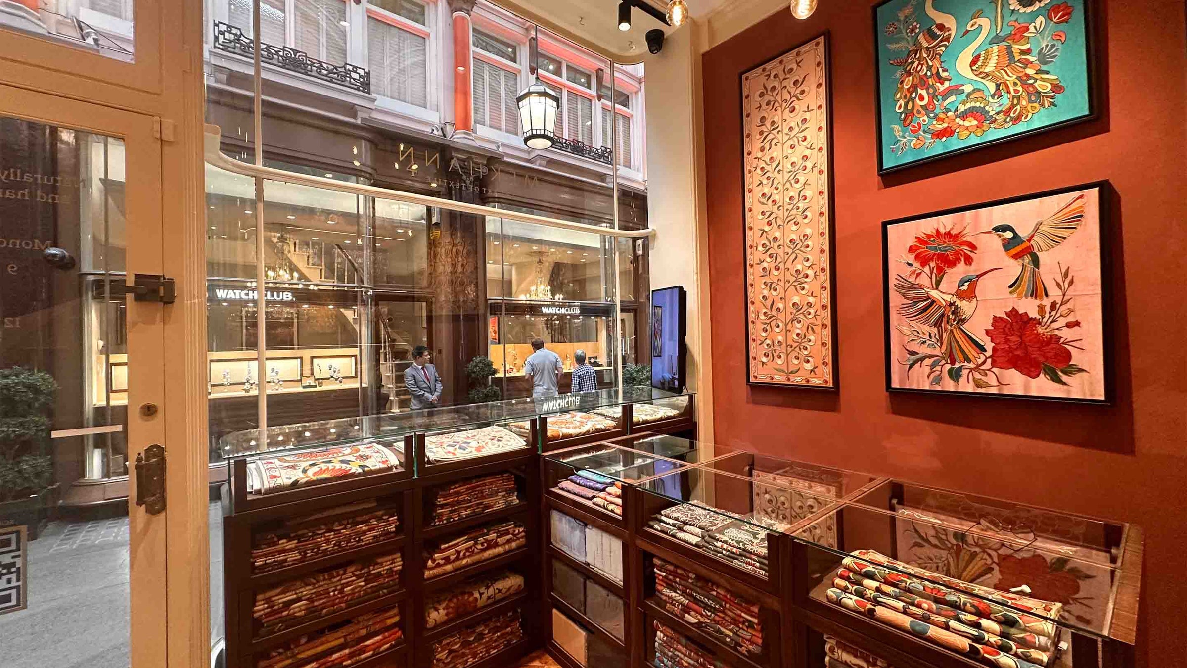 Interior of a store with display cases and framed artwork on the wall.