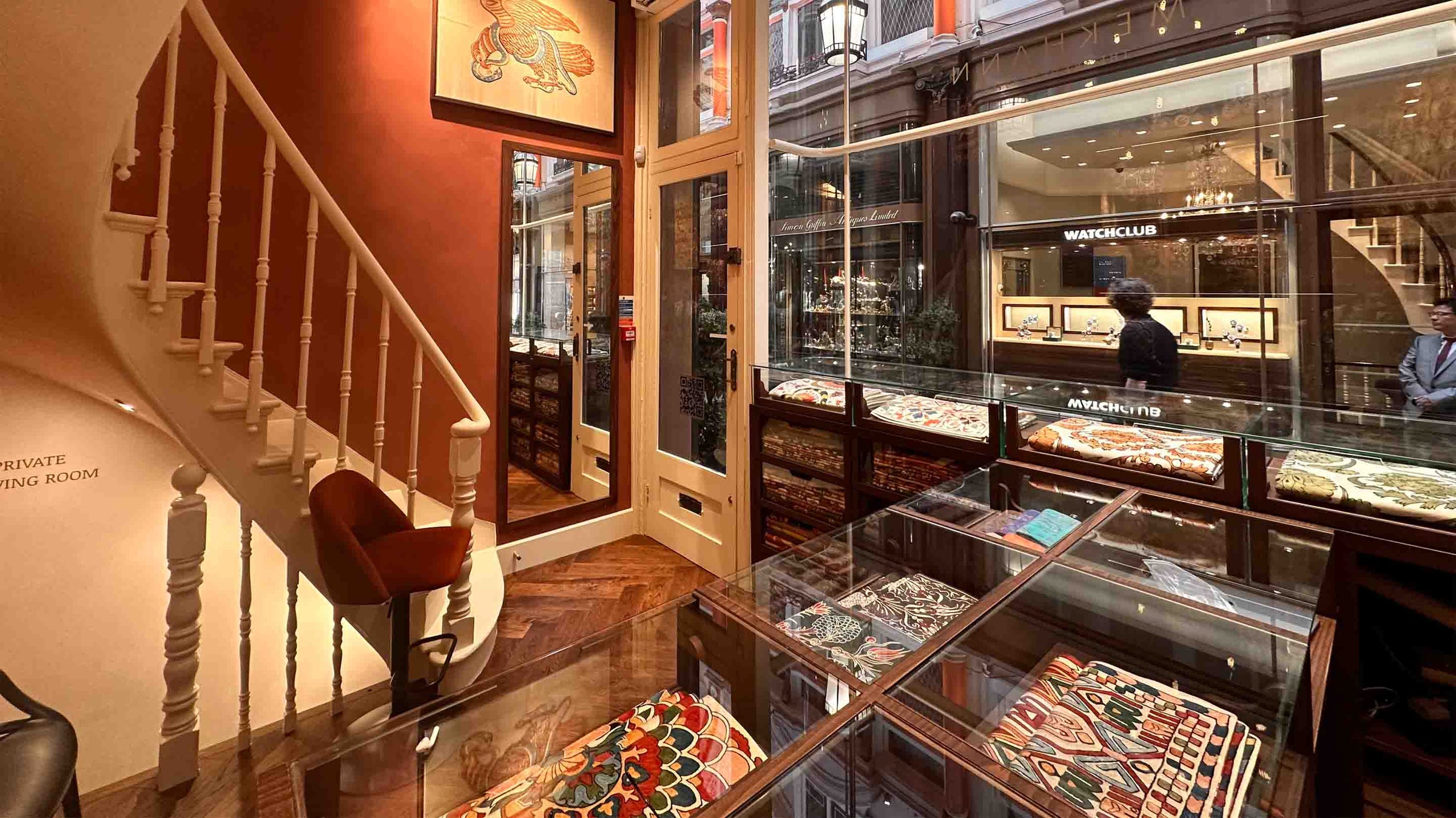 Interior of a textile store with display cases and staircase