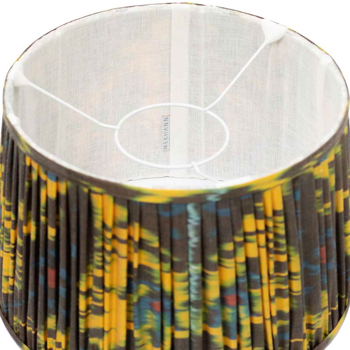 Interior shot of Mekhann's colourful ikat lampshade, displaying the luxurious silk texture and rich, plant-based dye hues.