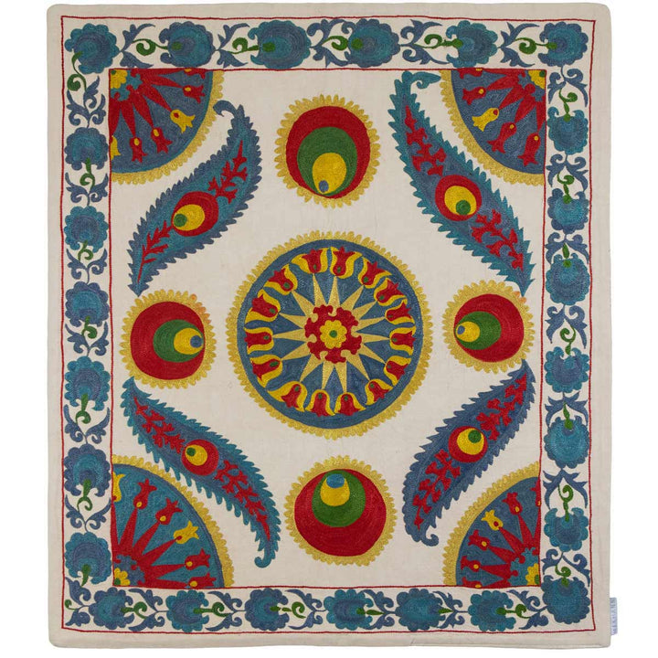 Front view of Mekhann's cream iznik silk petite throw, with many multicoloured floral and geometric patterns in yellow, red and blue and the dominant tones, all set on a base of cream coloured silk.