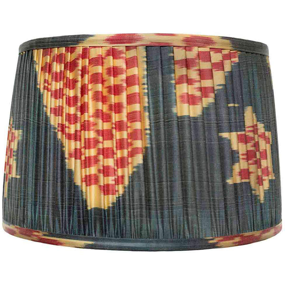 Front view of Mekhann's navy ikat silk lampshade, with a red and gold pattern, hand-pleated using eco-friendly dyes.