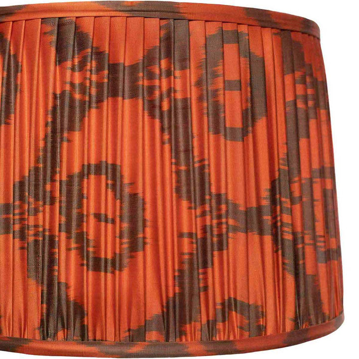 Close-up of Mekhann's orange ikat lampshade, showcasing the detailed handcrafted pattern and vibrant color palette.