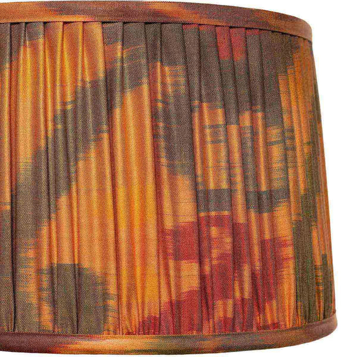 Close-up of Mekhann's orange ikat pattern lampshade, highlighting the intricate pleating and rich colour saturation.