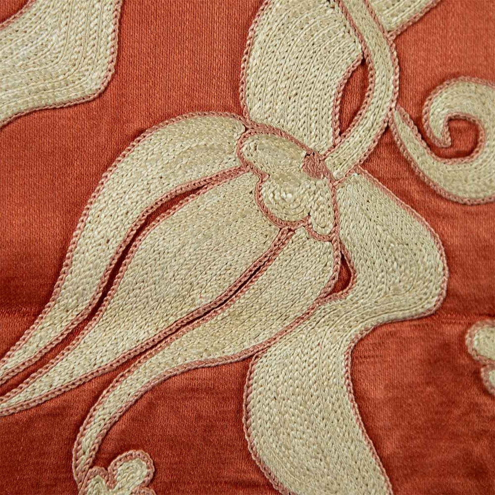 Close up view of Mekhann's orange ottoman vines runner, showing the detailed hand embroidered patterns on the orange silk backdrop.