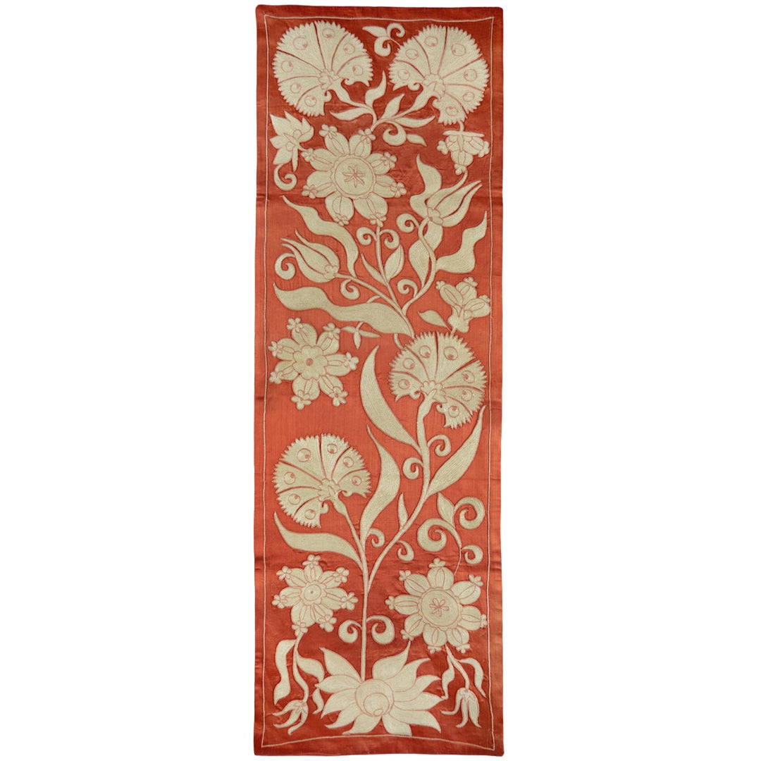 Front view of Mekhann's orange ottoman vines runner, featuring a cream Ottoman vines pattern that stretches the length of the runner and hand embroidered on orange silk, creating a vibrant and aesthetic.