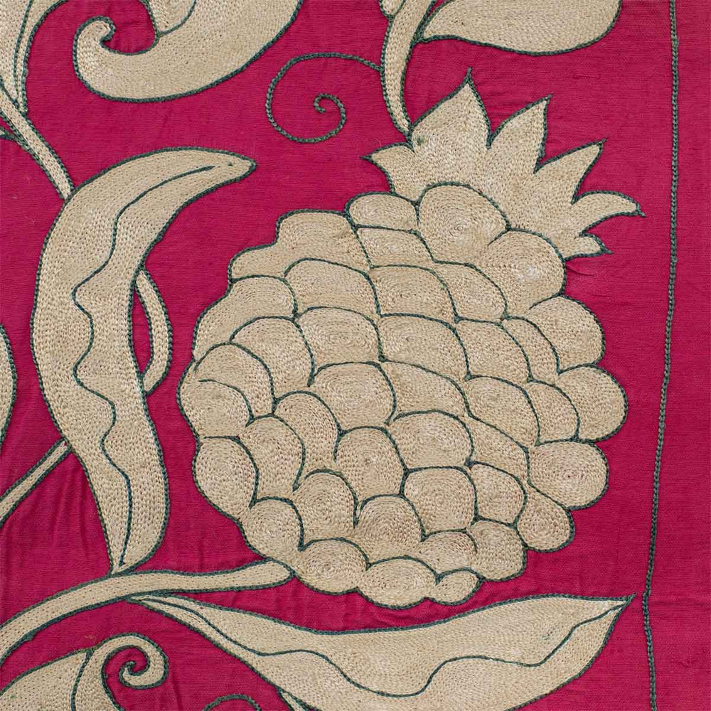 Close up view of Mekhann's pink ottoman vines runner, a close up of one of the motifs hand embroidered in cream and teal on pink onto a pink coloured silk.