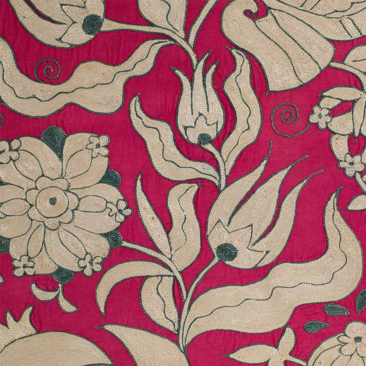 Detailed view of Mekhann's pink ottoman vines runner, showing the embroidered flowers and patterns up close in cream and teal against the pink silk background.