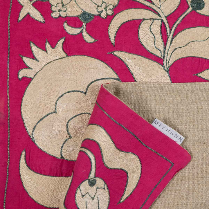 Folded view of Mekhann's pink ottoman vines runner, showing the beige back lining with the Mekhann label.