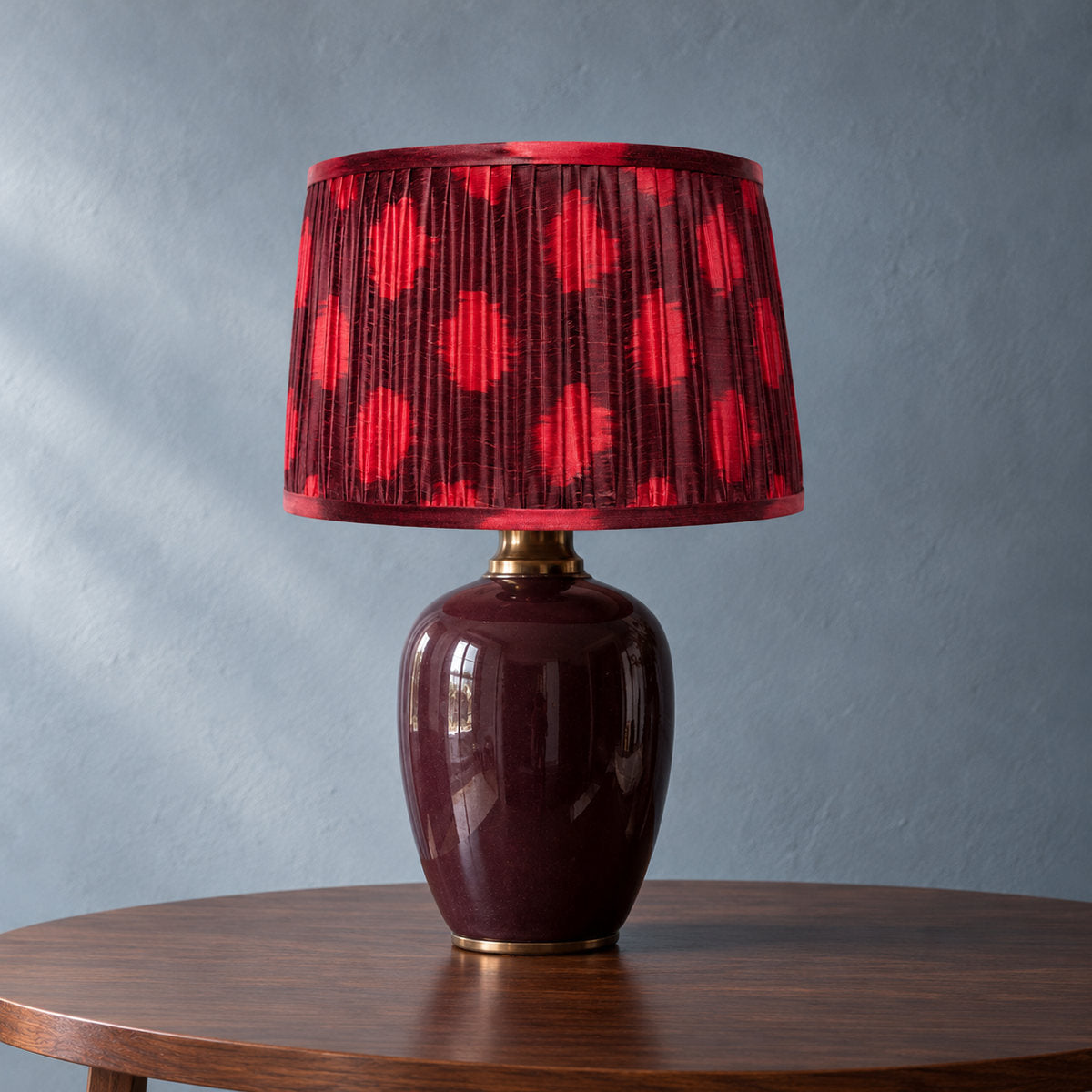 Polka Dot lampshade styled on an aubergine base against a blue-grey wall; illustrative full-lamp portrait.