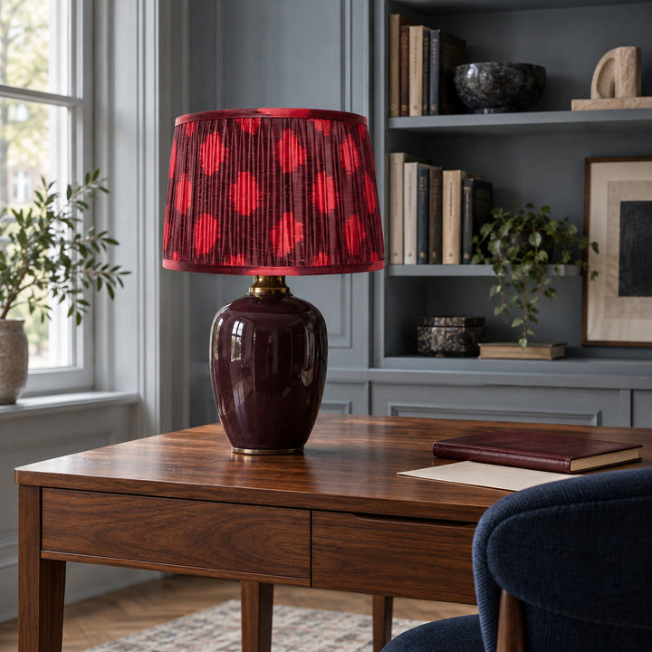 Polka Dot lampshade styled on an aubergine ceramic base at a walnut writing desk; illustrative study setting.
