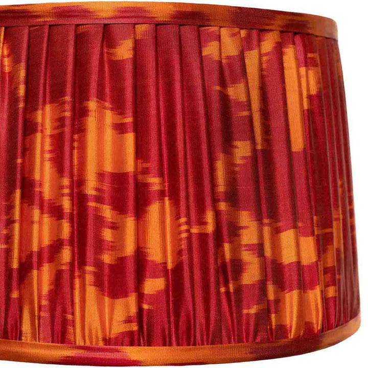 Close-up of the red and orange ikat design on Mekhann's silk lampshade, highlighting the detailed artisan dye work.