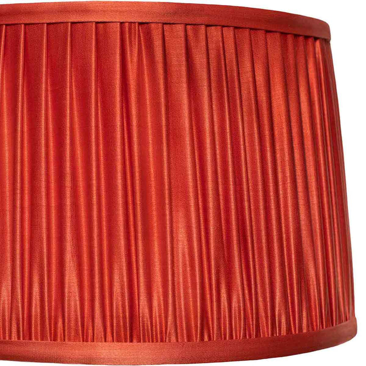 Detailed close-up of the intricate pleating on Mekhann's red silk lampshade, a testament to artisanal skill.