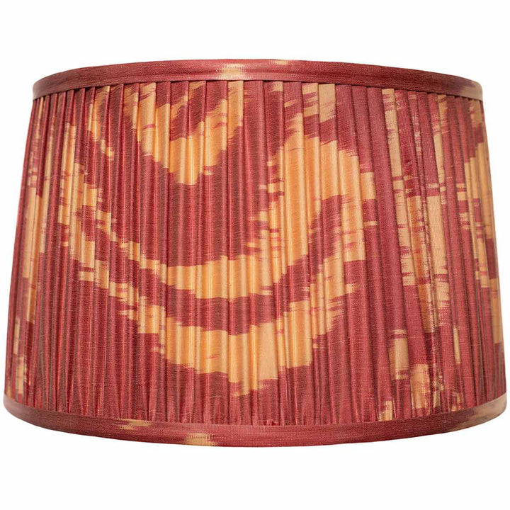 Front view of Mekhann's red and yellow ikat silk lampshade, hand-pleated with natural, vibrant dyes for a warm ambiance.