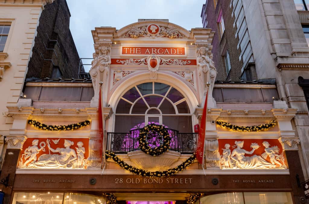 Decorative facade of The Arcade at 28 Old Bond Street with ornate architecture and lighting.