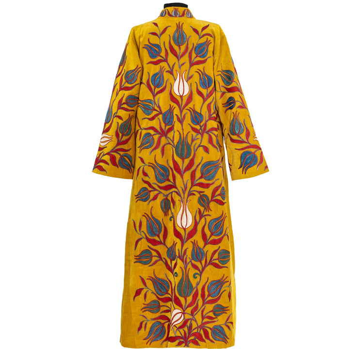 Back view of Mekhann's embroidered velvet tulips kaftan in saffron, revealing how the tulip patterns flows onto the back of the kaftan creating a well balanced design all over the kaftan.