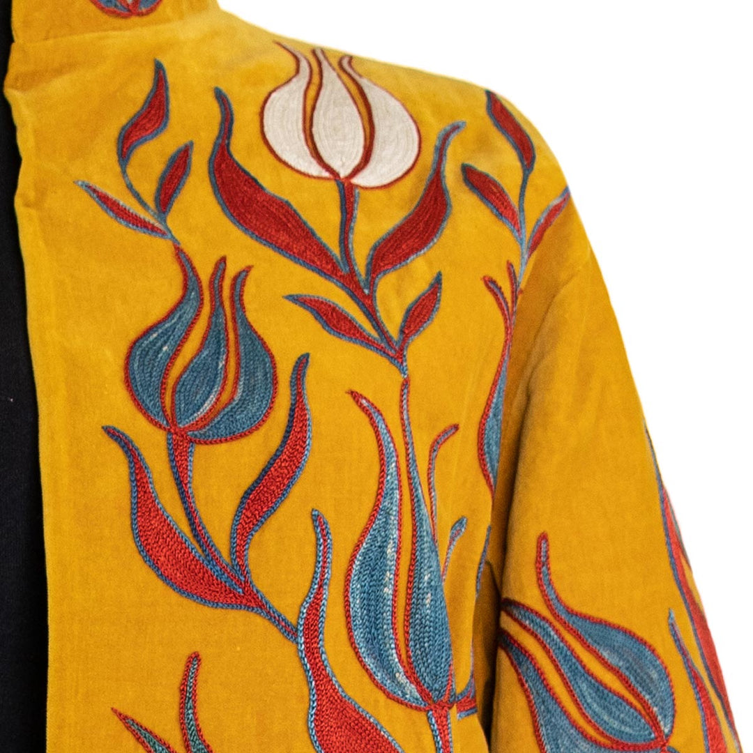 Shoulder view of Mekhann's embroidered velvet tulips kaftan in saffron, showing the natural shape of the tailored kaftan.