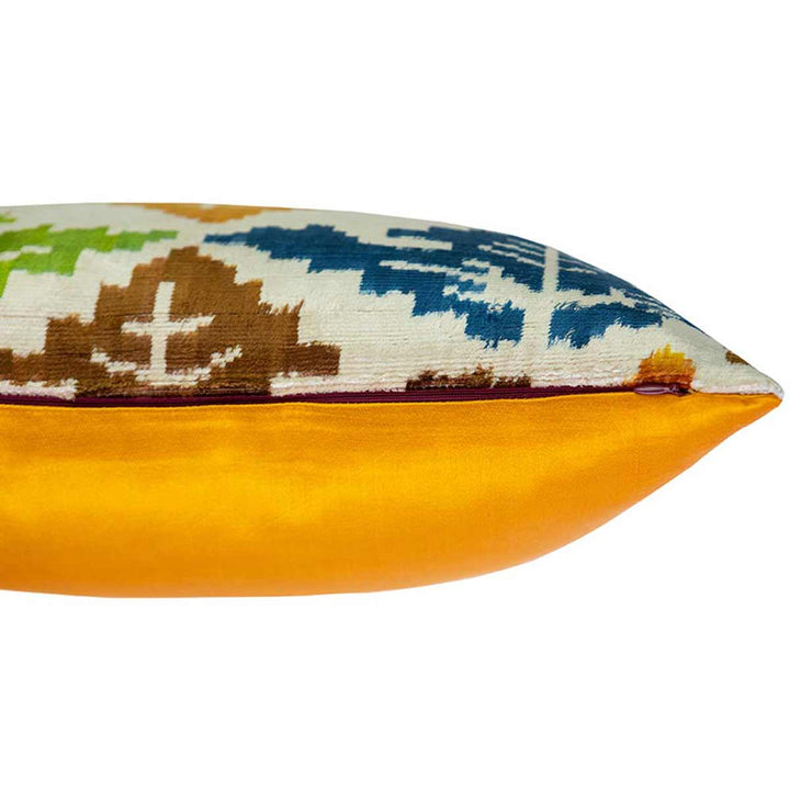 Side view of Mekhann's leaves patterns velvet cushion, showing the contrast between the bright yellow face face of the cushion and the multicoloured velvet front layer.