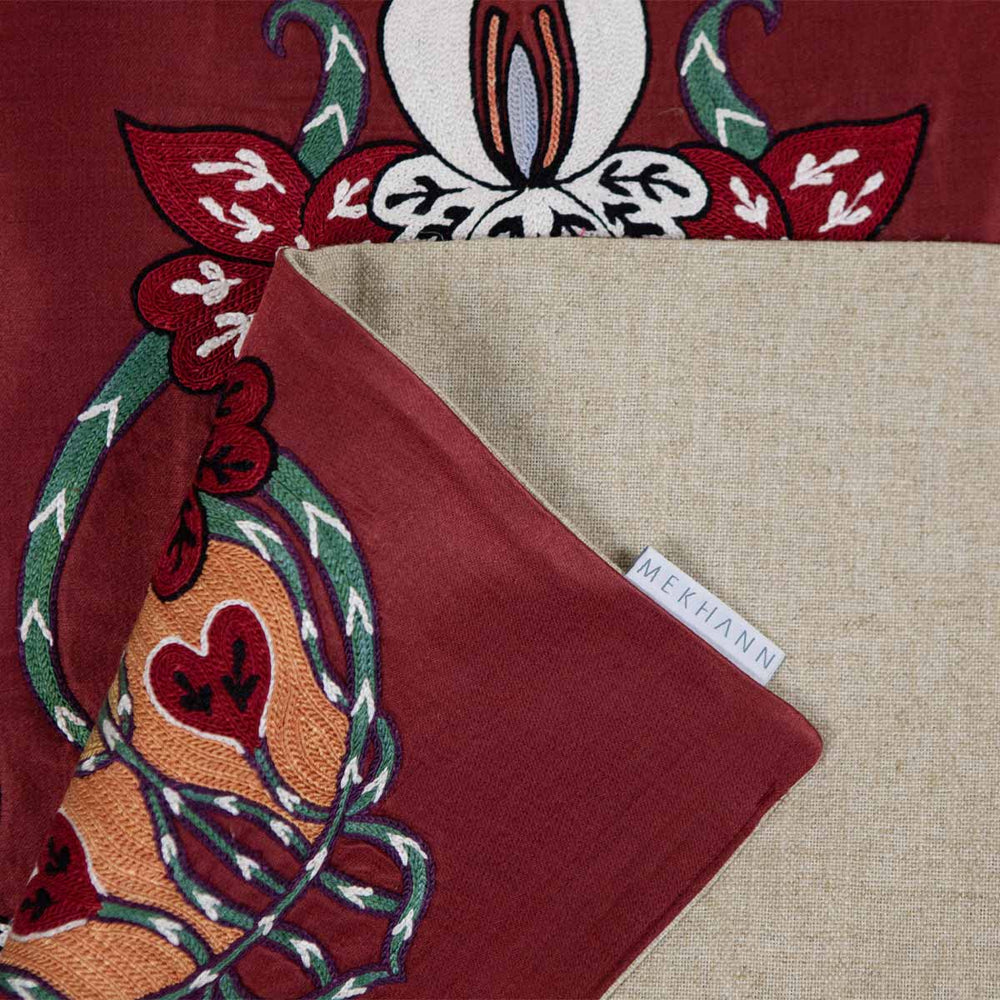 Alternative folded view of Mekhann's maroon baroque petite throw, showing another angle of the back lining with the Mekhann label on display.
