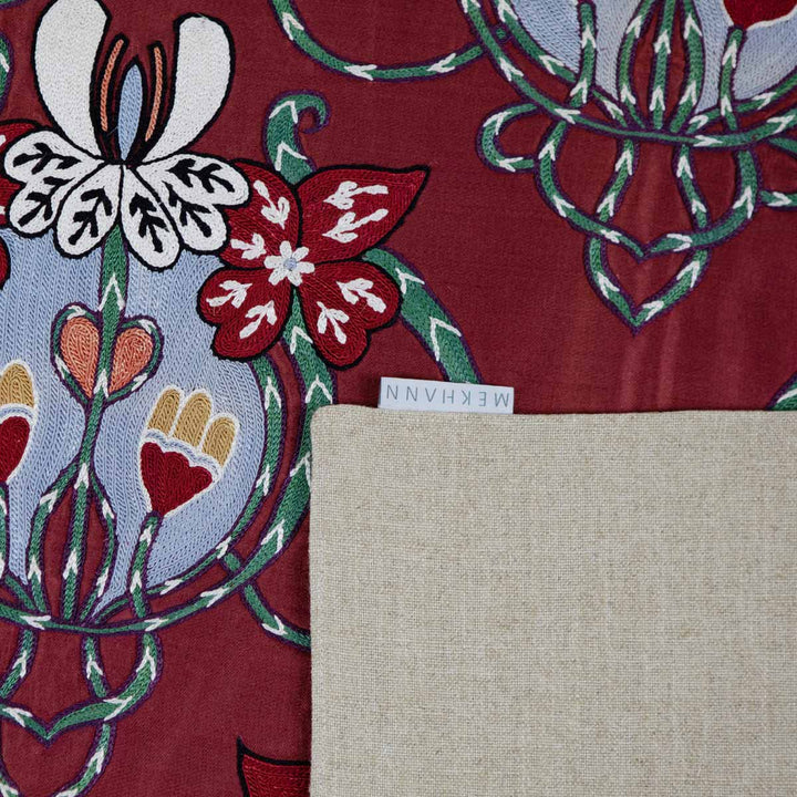 Folded view of Mekhann's maroon baroque petite throw, showing the back beige lining with the Mekhann label on display.