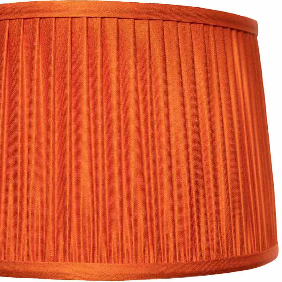 A detailed close-up of Mekhann's pure orange silk lampshade, showcasing the exquisite pleating and rich colour depth.