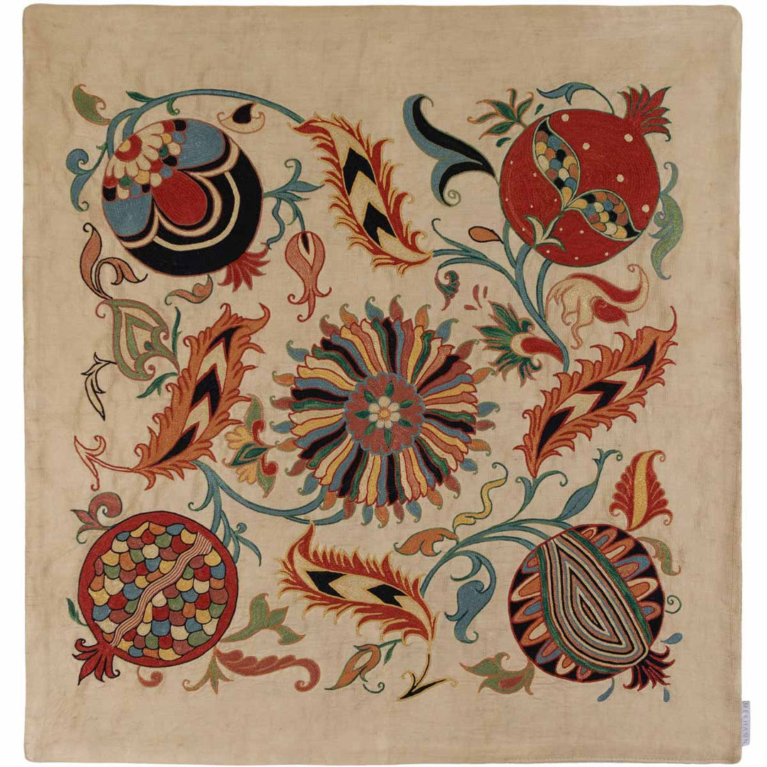 Front view of Mekhann's cream iznik petite throw, with a mix of intricate red, blue, and green organic hand embroidered patterns on a soft cream background.