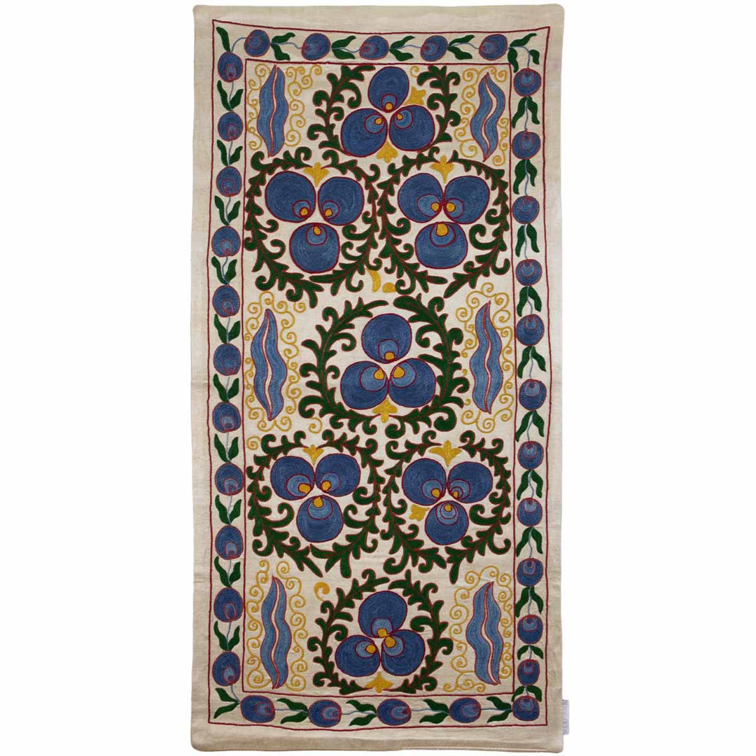 Front view of Mekhann's cream cintamani runner, displaying hand embroidered cintamani patterns surround by other hand embroidered decorative organic elements in colours blue, yellow, and green.
