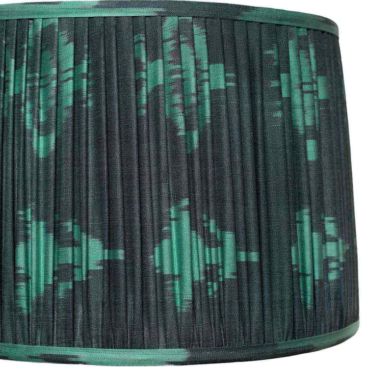 Close-up of Mekhann's teal ikat silk lampshade, focusing on the intricate pleating and vibrant, sustainably sourced dyes.