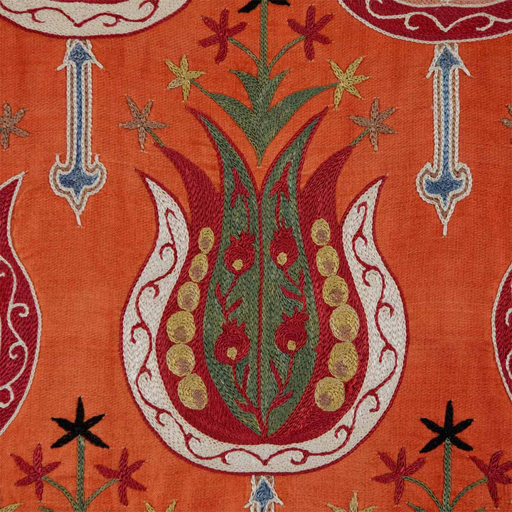 Detailed view of Mekhann's clementine tulip petite throw, showing the precision of tulip motifs against a vivid orange background.
