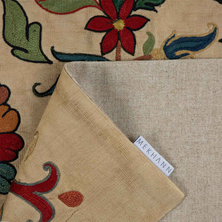 Folded view of Mekhann's silk tulip petite throw, showcasing the delicate patterns, the lining of the back of the throw with the Mekhann label. 