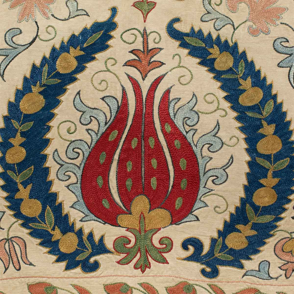 Close up view of Mekhann's cream tulips runner, showing up close the hand embroidered tulip design in blue, red, yellow and navy.