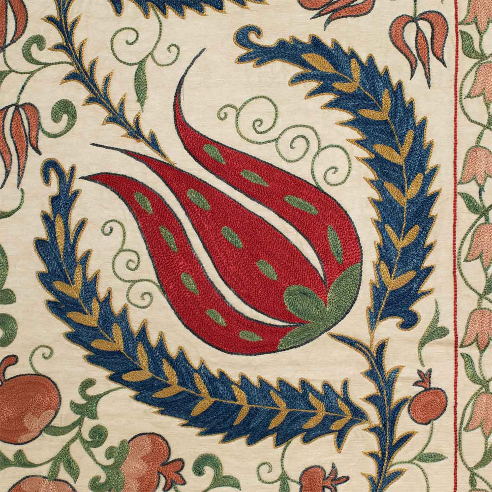 Close up view of Mekhann's cream tulips runner, showing the detail of the hand embroidered tulips and pomegranates in the frame work of the tulip runner.