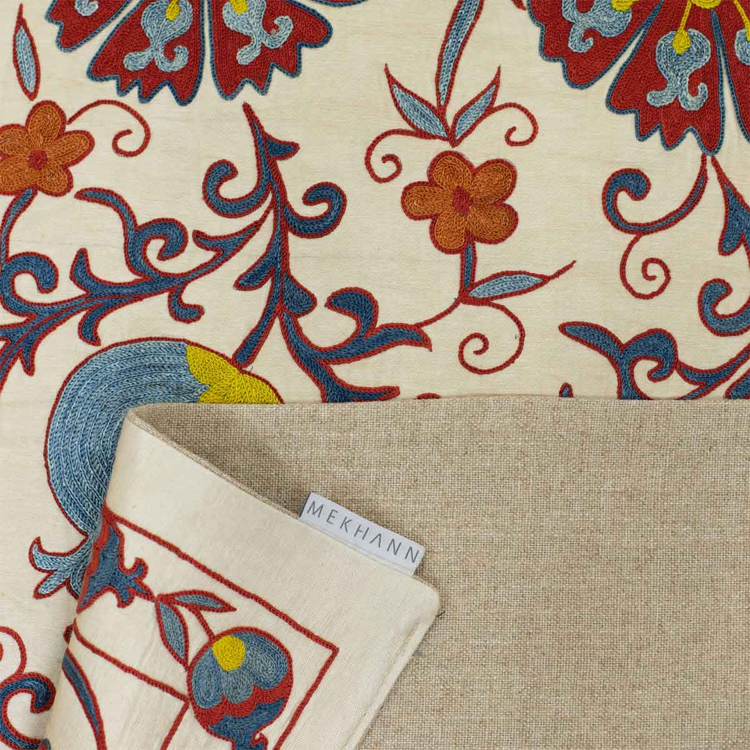 Folded view of Mekhann's cream tulips runner, showing how the beige lining complements the front of the runner and also showing the Mekhann label attached to the runner.