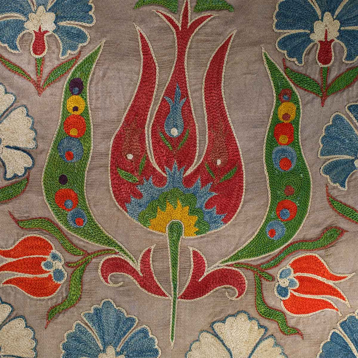 Close up view of Mekhann's grey tulip runner, showing up close the detail of the tulip embroidery in bright red against the grey silk background.