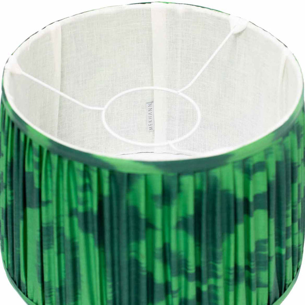 Interior view of Mekhann's hand-pleated silk lampshade, featuring a lush two-tone green ikat design for an organic aesthetic.
