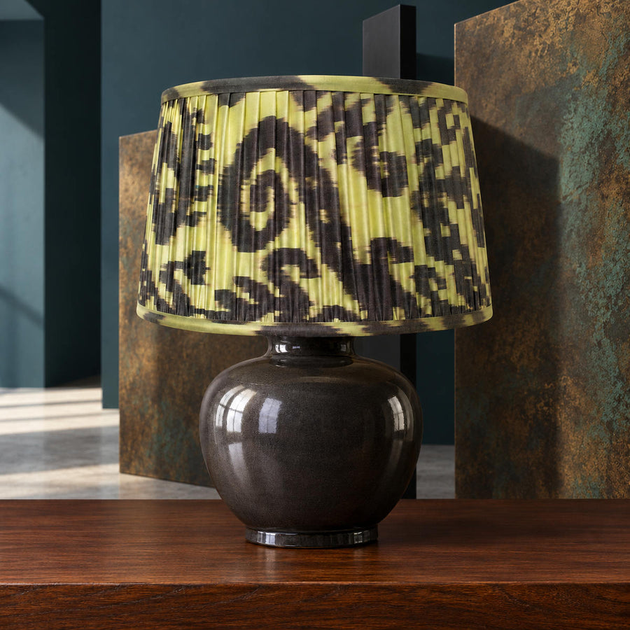 Volute lampshade styled with geometric screens and patinated metal; illustrative architectural setting.