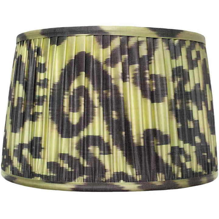 Medium Volute silk ikat lampshade with dark scrolling motifs on a pale ground, front view.