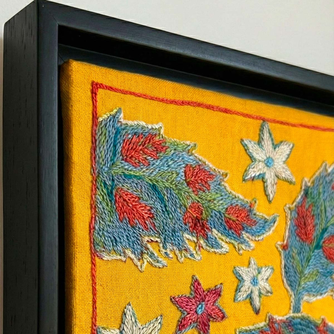 Embroidered fabric with floral patterns in a black frame