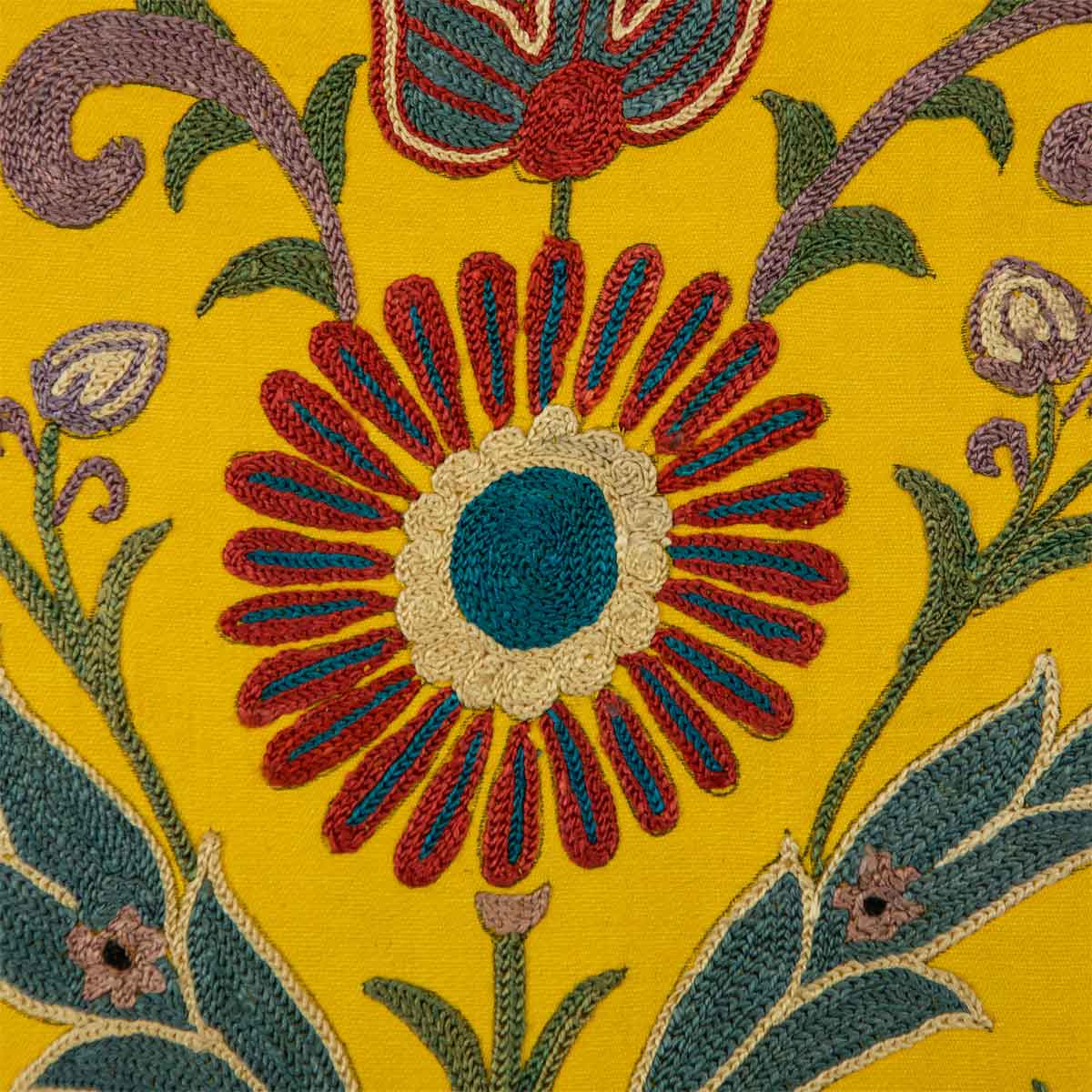 Up close view of Mekhann's yellow silk artwork with hand embroidered floral shapes. Revealing the main centre flower with blue and red embroidered petals embroidered onto a yellow silk base.