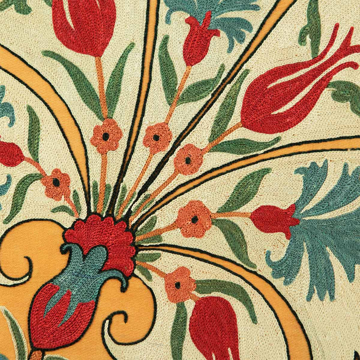 Close up view of Mekhann's yellow silk carnations embroidered artwork, showing the intricate details of the embroidered patterns within the main cream carnations. Featuring smaller red, blue and orange flowers.