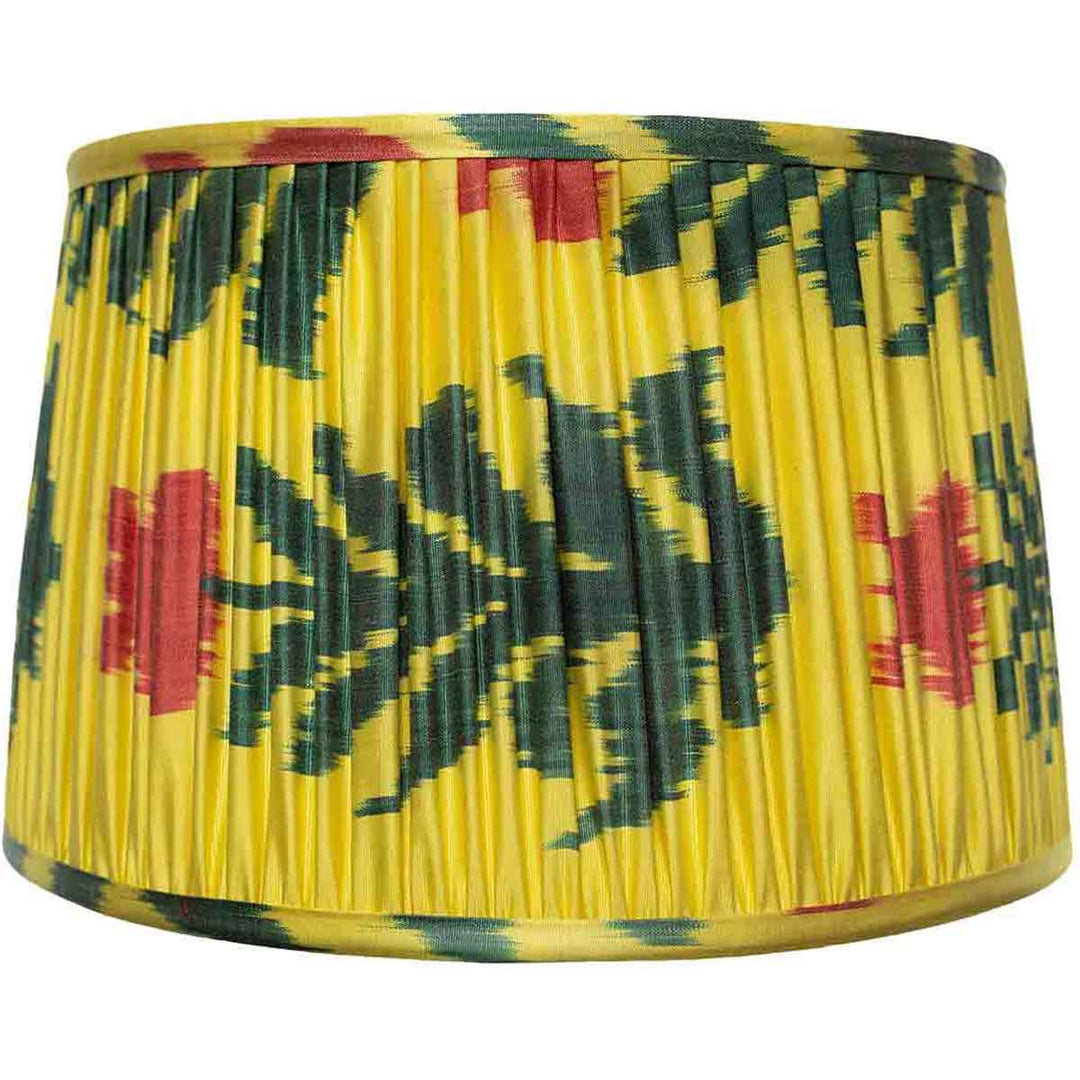 Front view of Mekhann's saffron floral ikat silk lampshade, hand-pleated with green and red patterns, crafted with natural dyes.